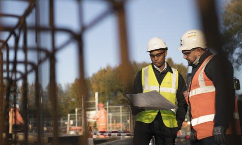 Two men wearing PPE on construction site for National Grid 'Can we achieve carbon-neutral construction by 2026?' story
