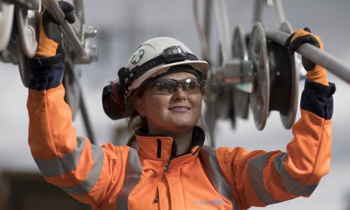 Female engineer wearing PPE holding National Grid high-voltage power cables