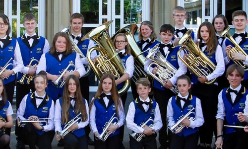 Youth brass band wearing uniform and holding their instruments