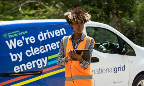 Woman wearing high-vis vest in front of National Grid EV van - used for launch of National Grid's Responsible Business Charter