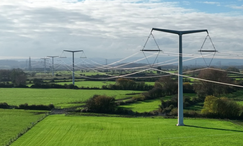 T-pylons and overhead electricity lines across green fields