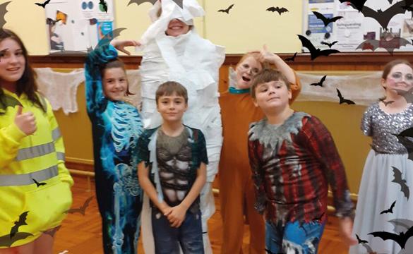 Children dressed in Halloween outfits with superimposed bats in the foreground