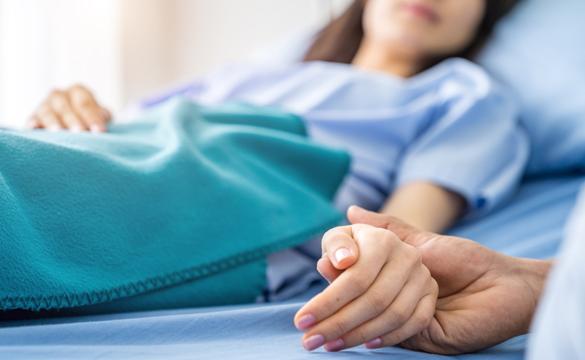 Holding hands with hospital patient for National Grid story 'Supporting carers during stressful times'