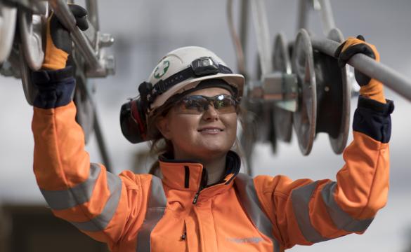 Female engineer wearing PPE holding National Grid high-voltage power cables