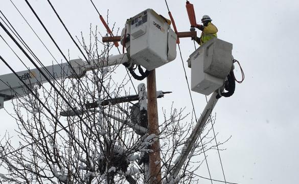 National Grid lineworker fixing a power line in the snow in the US