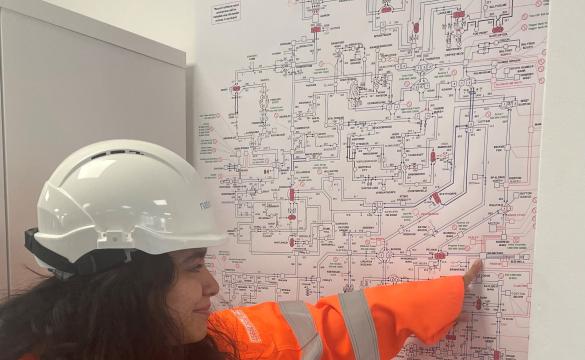 National Grid's Tanya Bukhari wearing PPE and pointing at a diagram on the wall