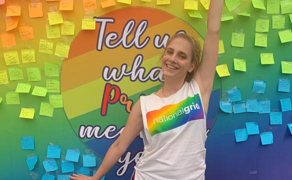 National Grid Pride colleague in front of colourful board with posters